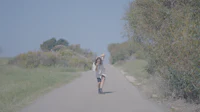 a girl is riding a skateboard down a road