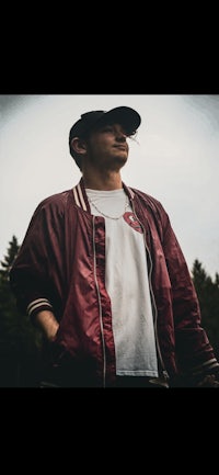 a man wearing a red jacket and white t - shirt