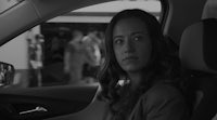 a woman sitting in a car looking out the window