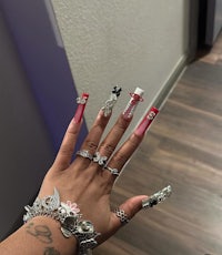 a woman's hands with a lot of jewelry on them