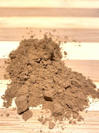 a pile of brown powder on a wooden surface