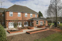 a red brick building with a garden in front of it