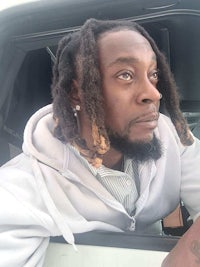 a man with dreadlocks sitting in a car