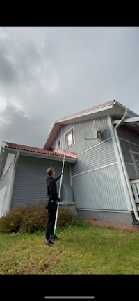 a man cleaning the roof of a house