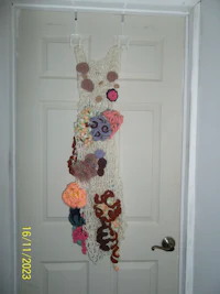 a crocheted dress hanging on a door