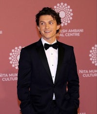 a young man in a tuxedo standing on a red carpet