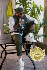 a man sitting on a bench with a plant in front of him