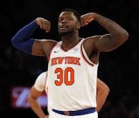 the new york knicks player is pointing his fingers in the air