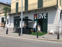 a man is standing in front of a building with a sign that says love