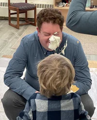 a man is eating cake with a little boy