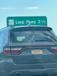 a car driving down the road with a sign that says loop pywy
