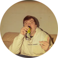 a man sitting on a couch with a beer in his hand