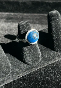 a silver ring with a blue stone on it