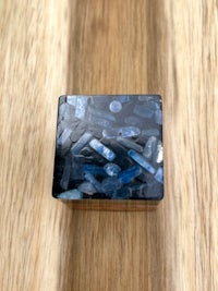 a blue stone box on top of a wooden table