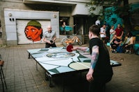 a group of people playing ping pong on a street