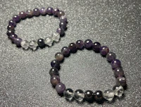 two amethyst bracelets on a black surface