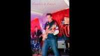 a man playing a guitar in a bar