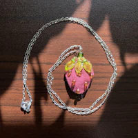 a pink strawberry pendant on a silver chain