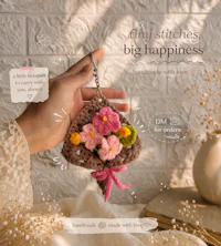 a person holding a crocheted flower keychain