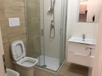 a bathroom with a toilet, sink and shower stall