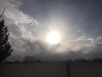 the sun shines through a cloudy sky