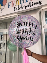 a person holding a balloon that says happy birthday christ