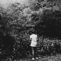a black and white photo of a woman standing in the woods