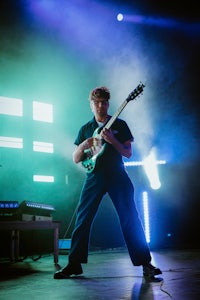 a man playing a guitar on stage