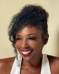 a woman with a curly afro smiles for the camera