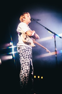 a man holding a guitar on stage