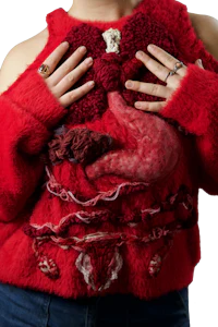 a woman wearing a red sweater with her hands on her stomach