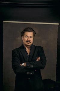a man in a black suit posing for a photo