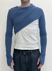 a man wearing a blue sleeveless shirt and jeans