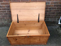 a small wooden chest with a lid on it