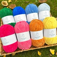 a basket full of colorful yarn in a grassy area