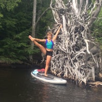 a woman doing yoga on a stand up paddle board