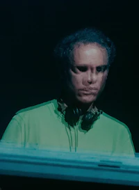 a man in a green shirt with headphones on