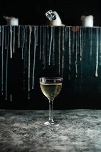 a cocktail with ice in a glass on a table