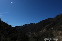 a blue sky with mountains in the background