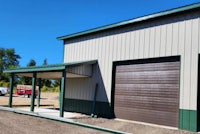 a metal building with a green garage door