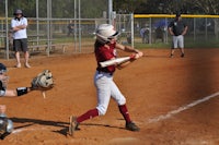 a girl swinging a bat at a ball