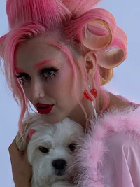 a woman with pink hair holding a white dog