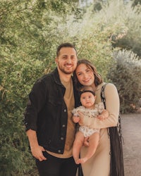 a family poses for a photo in the desert with their baby
