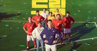 a group of people standing on a soccer field
