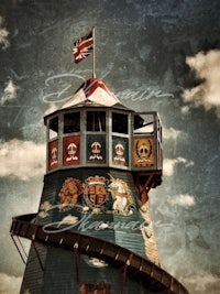 an old fashioned amusement tower with a flag on it