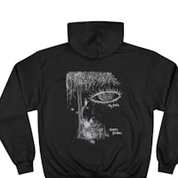 a black hoodie with an image of an eye in the forest