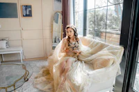 a woman in a gold dress sitting on a couch