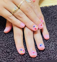 a woman's hand with colorful nail art and a ring on it