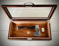 a wooden box with an axe and a knife inside