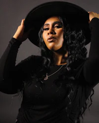 a woman in a black hat posing for a photo